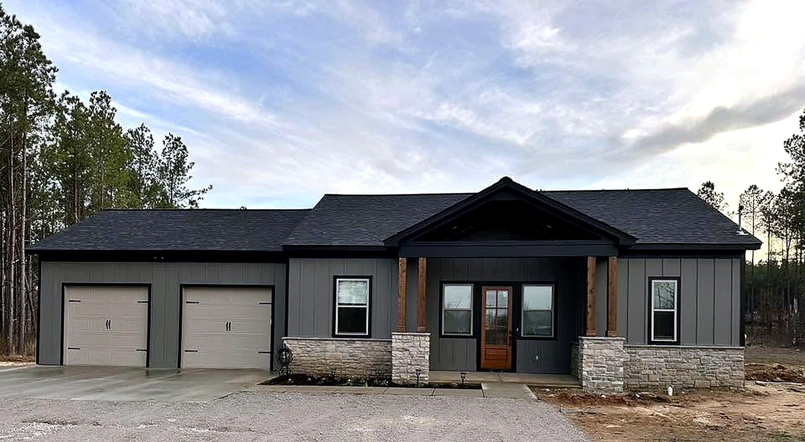 Wide gray custom home exterior under construction by M & D Custom Homes